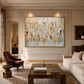 Gilded Fragments artwork displayed above a pale sofa in a paneled room.