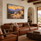 Frontier Overlook artwork displayed above a brown leather sofa.