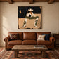 Starboot Muse artwork displayed above a brown sofa beneath wood beams.