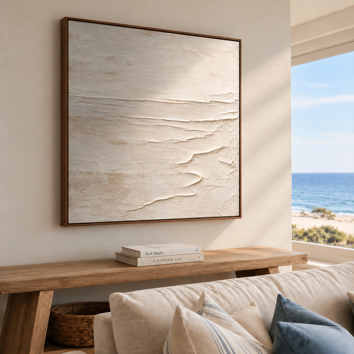 Quiet Foreshore artwork displayed above a wood console beside seating and an ocean-view window.