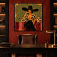 Leopard Reverie artwork displayed above a dark wood desk and leather chair with a brass lamp.