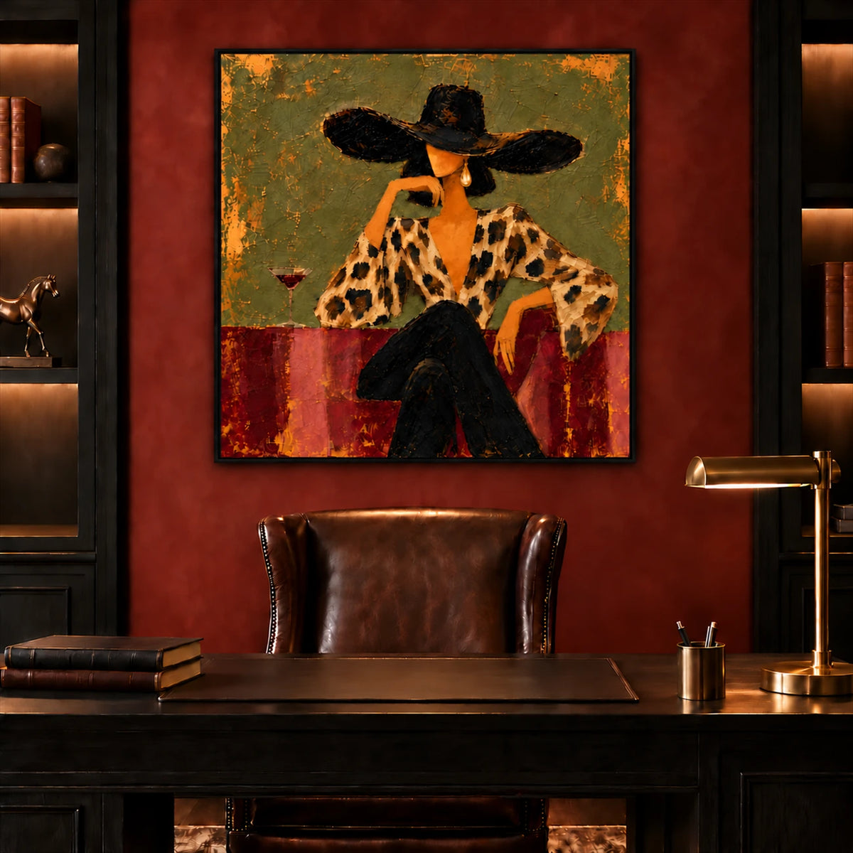 Leopard Reverie artwork displayed above a dark wood desk and leather chair with a brass lamp.