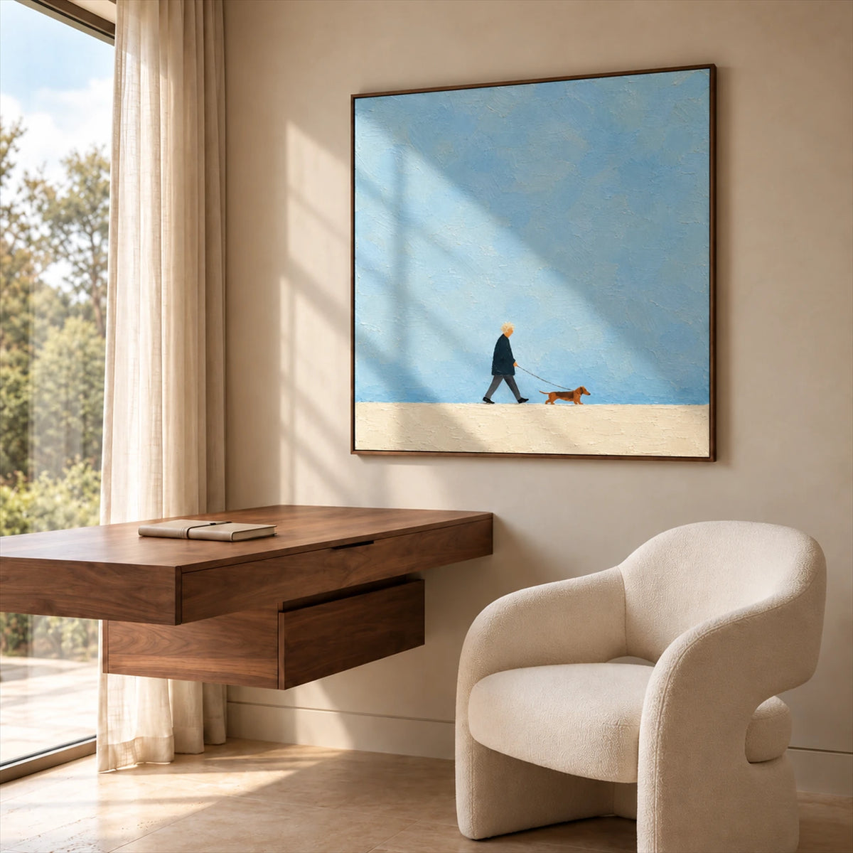 Little Stroll artwork displayed above a wood desk beside a cream armchair.