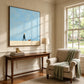 Little Stroll artwork displayed above a console beside a green armchair.