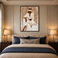 Ivory Composure artwork displayed above a bed with navy bedding.