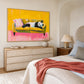 Panda Pause artwork displayed above a wooden dresser beside a bed.
