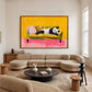 Panda Pause artwork displayed above a curved cream sofa in a living room.