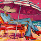 Parasol Escape full artwork. A reclining figure in blue rests beneath a striped beach parasol, with red boots stretched toward the sea.