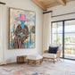 Fuchsia Reverie artwork displayed beside rattan seating in a bright room.